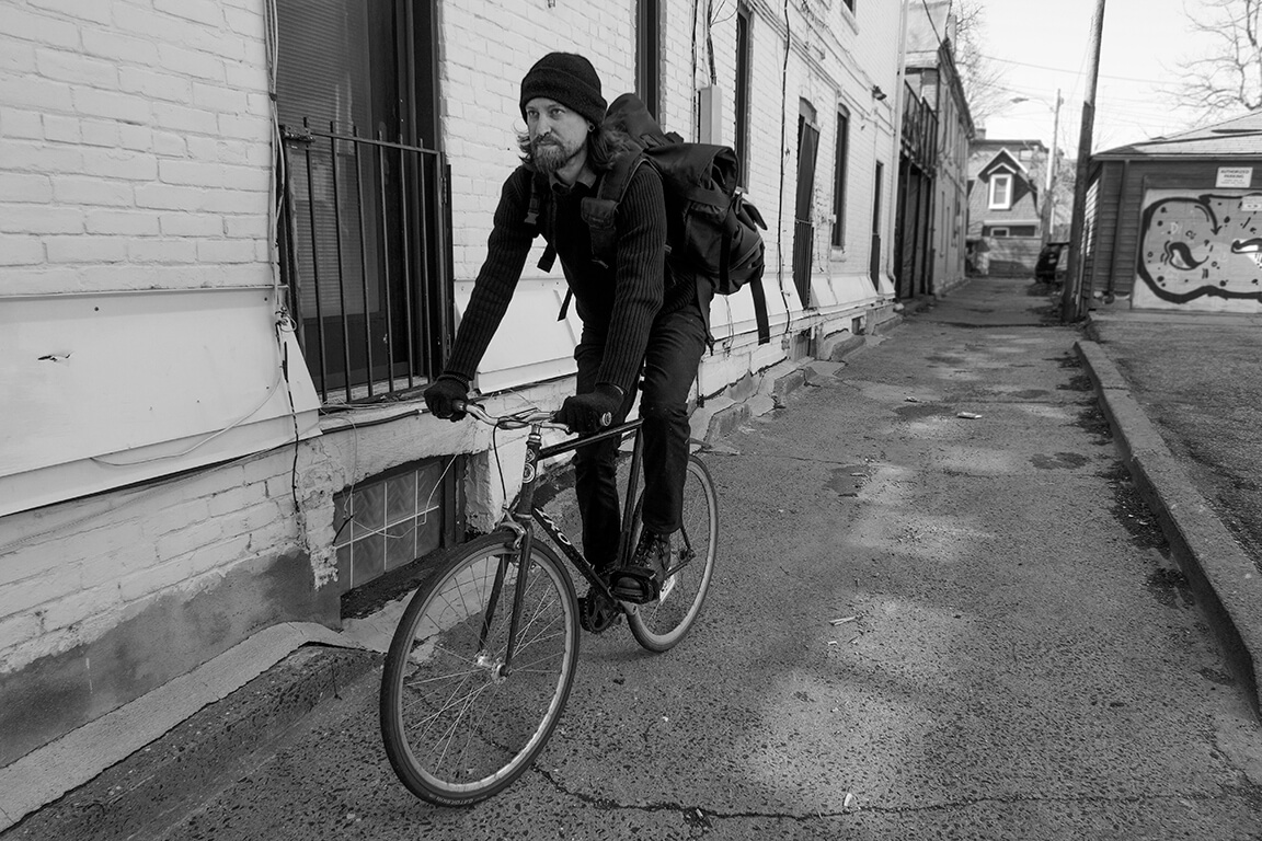 Foodster riding a bike near a building